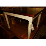 A contemporary hardwood and cream painted rectangular kitchen table, raised on turned and fluted