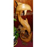 A contemporary Eastern carved teak freestanding sculpture of intertwined dolphins, on naturalistic
