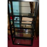 A contemporary ebonised freestanding five-tier display stand, with glass inset shelves, w.76.5cm