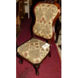 A mid-Victorian figured walnut floral relief carved nursing chair, having floral embroidered