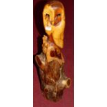 A contemporary carved root-wood model owl, to a naturalistic bark base, h.85cm