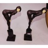 A pair of Art Deco style resin figures of women in bent pose, each mounted upon an hexagonal plinth,