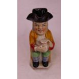 A Staffordshire style pottery Toby jug, in the form of a seated figure wearing a tricorn hat with