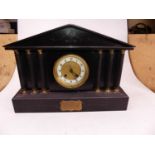 An early 20th century black slate eight-day mantel clock, of architectural form, the enamelled