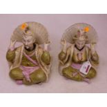 A pair of 20th century porcelain nodding pagoda figures, each shown in seated pose with raised