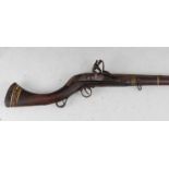 * A 19th century Afghan flintlock jezail musket, having a 104cm steel barrel with six copper bands