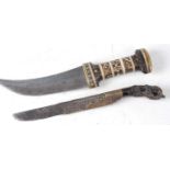 * A Phia kaetta, the 16cm single edged blade with foliate engraved decoration, having a brass collar