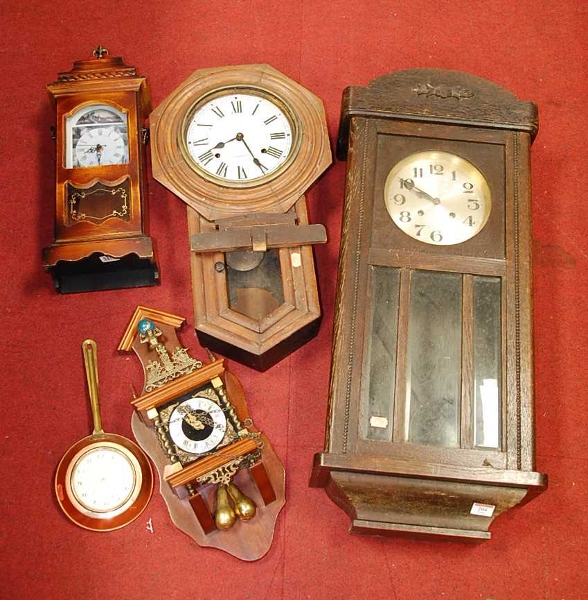 A 1930s oak cased wall clock; together with a droptrunk wall clock; and two others (4)