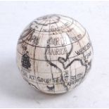 A reproduction faux ivory model of a pocket globe, opening to reveal a compass