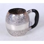 An Arabic(?) white metal tankard, of barrel form, having a frieze of repousee decorated flowers,