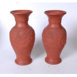 A pair of 20th century Chinese export terracotta vases, of baluster form, each relief decorated with