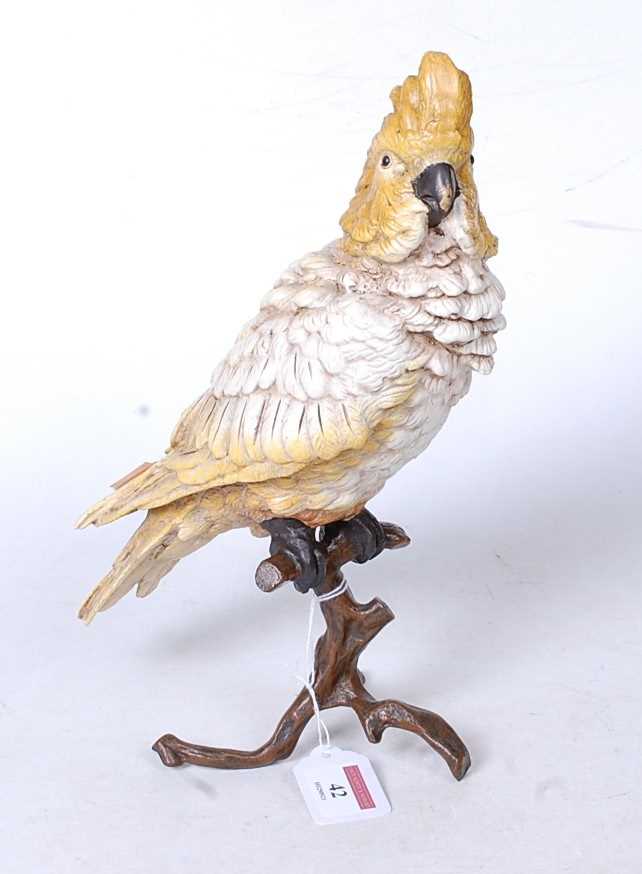 A modern cold-painted bronze model of a parakeet perched on a branch, h.30cm