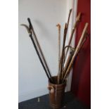 A turned oak bucket containing a collection of shepherd's crooks and walking canes