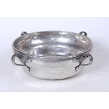 An Arts & Crafts style hammered pewter bowl, of circular form, having four sinuous loop handles,