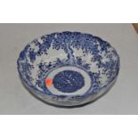 A Chinese style bowl of lobed circular form, underglaze blue decorated with trees and flowers, dia.