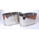 A pair of plated champagne buckets, each engraved with a quote from Lily Bollinger and Napoleon