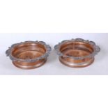 A pair of Victorian Old Sheffield Plate bottle coasters, having turned mahogany bases within a