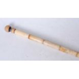 A faux ivory walking stick, each section carved with a female figure, having a turned wooden handle,