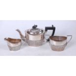 An Edwardian silver bachelors three-piece tea service, of half-gadrooned oval form, to include