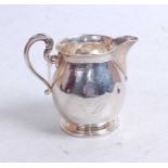 An early 20th century silver cream jug, of bell shape, having C-scroll handle and remains of