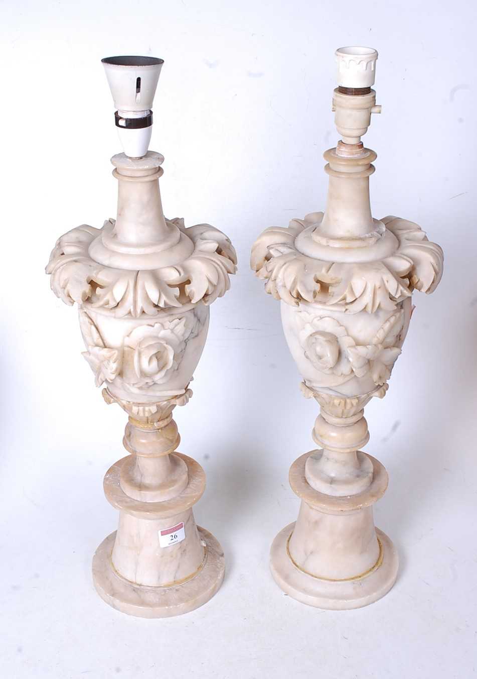 A pair of early 20th century onyx table lamps, each of urn shape with applied floral decoration, h.