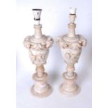 A pair of early 20th century onyx table lamps, each of urn shape with applied floral decoration, h.