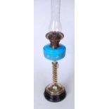 A Victorian oil lamp having a blue glass and floral enamelled font on a brass spirally turned column