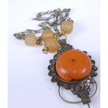 A base metal and faux amber set oversize pendant, on beaded neck chain