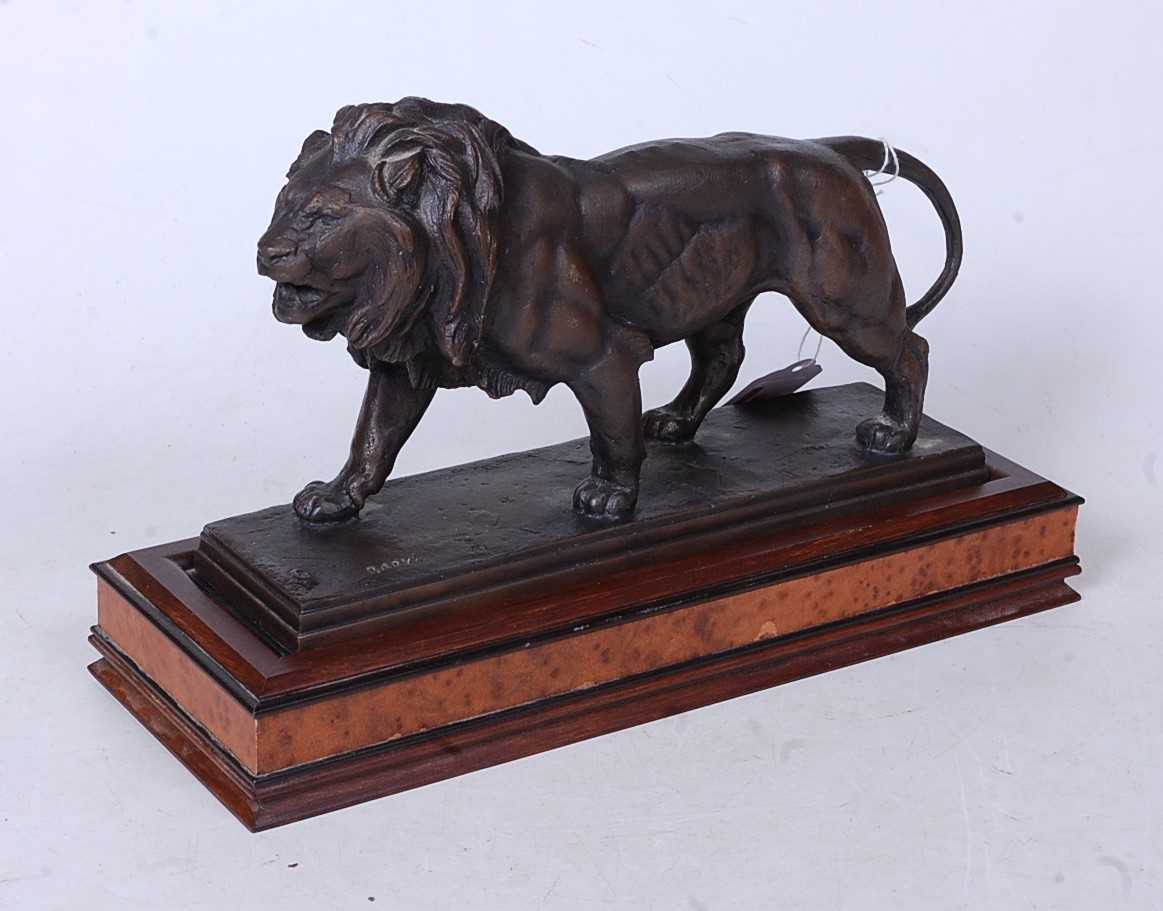 After Antoine Louis Bayre - a bronzed metal model of a lion in stalking pose, on a rectangular