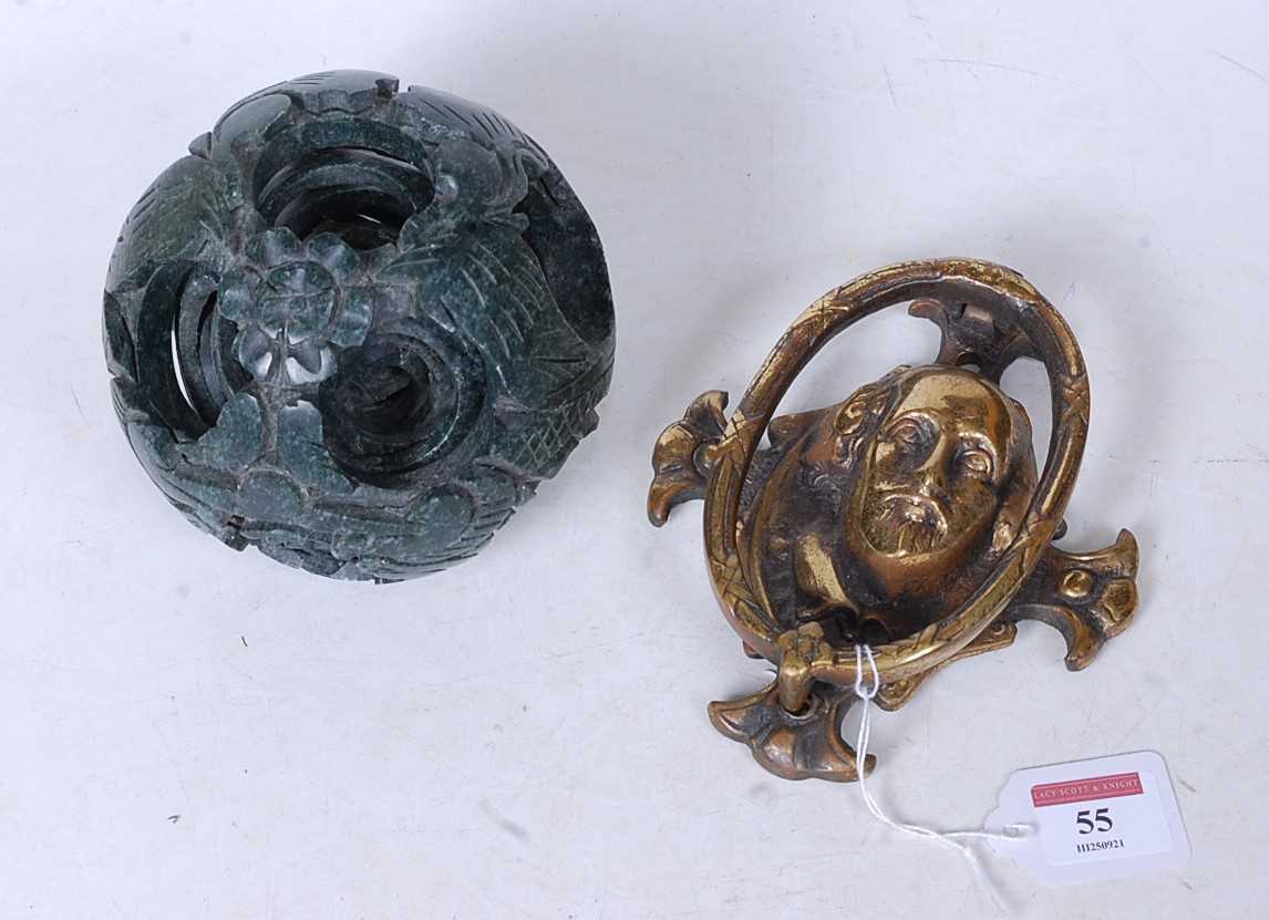 A carved and polished hard stone puzzle ball, together with a brass door knocker in the form of