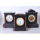 A late Victorian black slate and rouge marble mantel clock having a circular enamel dial with
