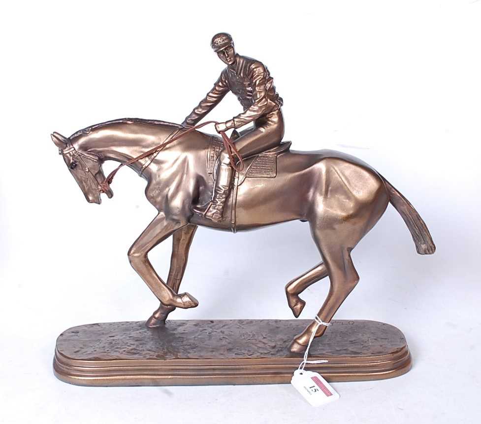 A reproduction bronzed resin figure of a racehorse and jockey, on naturalistic oval plinth, h.32cm