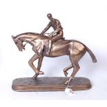 A reproduction bronzed resin figure of a racehorse and jockey, on naturalistic oval plinth, h.32cm