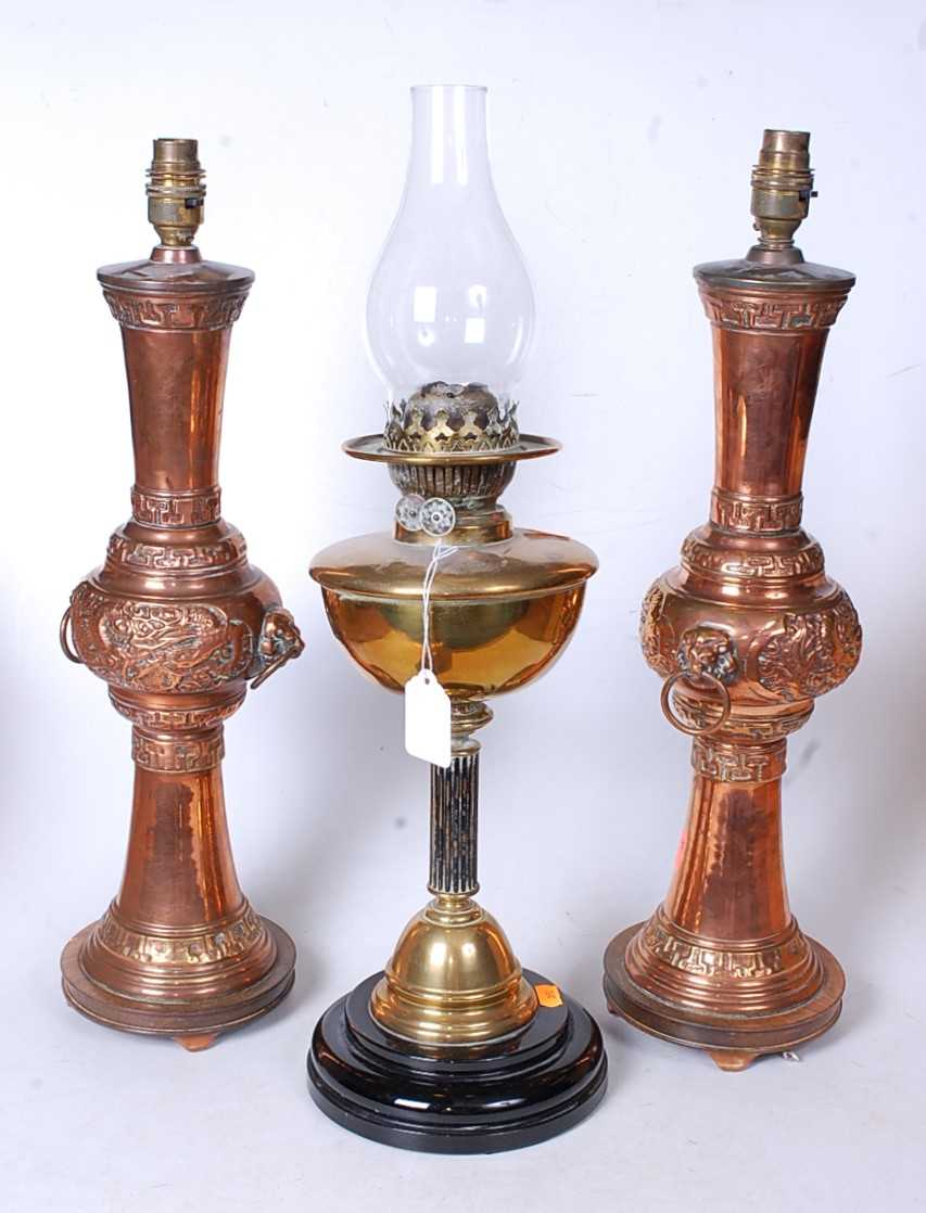 A late Victorian oil lamp having a brass font on a fluted column and domed base, 37cm, together with