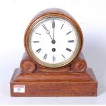 A late Victorian oak cased drumhead mantel clock, having an enamelled dial with Roman numerals and
