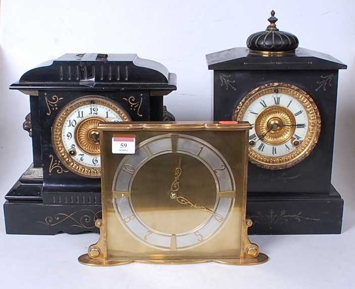 A late Victorian black slate mantel clock of architectural form having an enamelled chapter ring