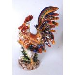 A large 20th century Continental glazed model of a cockerel, in standing pose on naturalistic