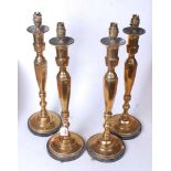 A set of four 20th century turned brass table lamps, each on an ebonised plinth, h.49cm (excluding