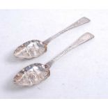 A pair of Victorian Irish silver berry spoons, having later embossed bowls and engraved terminals,