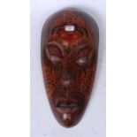 An African souvenir wear mask of elongated form with painted decoration 50cm