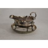 A silver sauceboat, having a wavy rim, flaying C-scroll handle, on cast shell feet, marks rubbed;