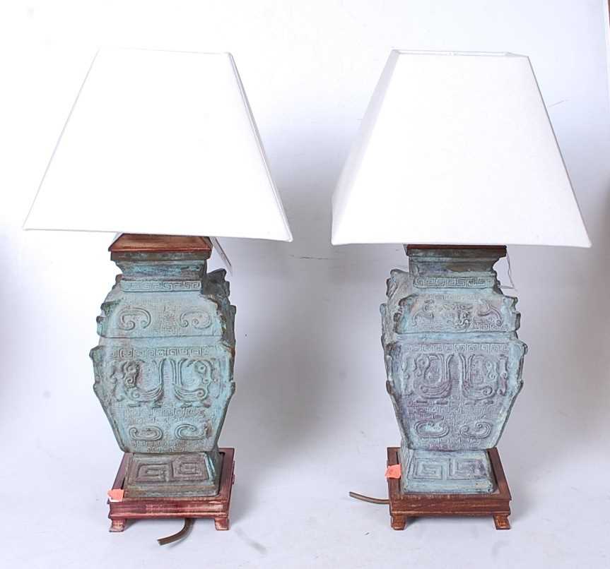 A pair of Chinese bronze table lamps, of square section, having incised Greek Key type decoration