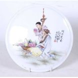 A Chinese export porcelain roundel, of convex circular form, enamel decorated with a man and a boy
