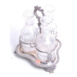 A late Victorian Old Sheffield Plate three-bottle decanter cruet, having a loop handle and scrolling