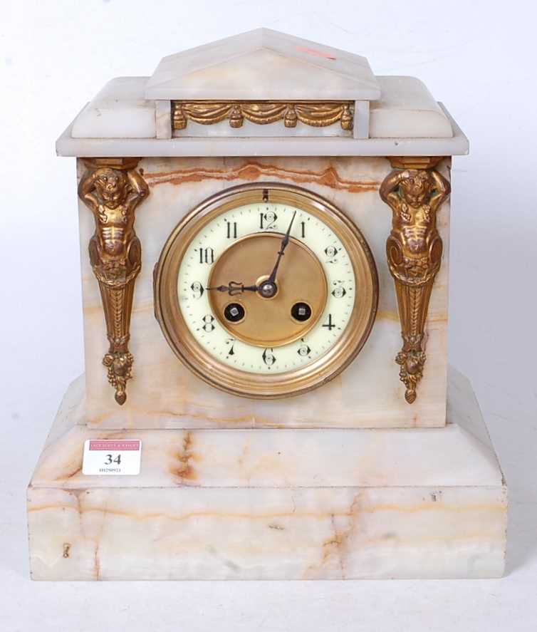 A late Victorian alabaster cased mantel clock, of architectural form with Egyptian revival type gilt