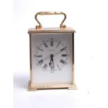 A 20th century lacquered brass cased mantel clock, having a silvered dial with Roman numerals and