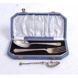 A George V silver christening fork and spoon in associated leather case together with one other