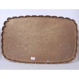 An Arts & Crafts brass tray, of shaped rectangular form, having all-over floral engraved decoration,