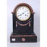 A late Victorian black slate and rouge marble dome topped mantel clock, the enamelled dial with