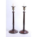 A pair of 19th century mahogany and brass table candlesticks, each with fluted and spirally turned